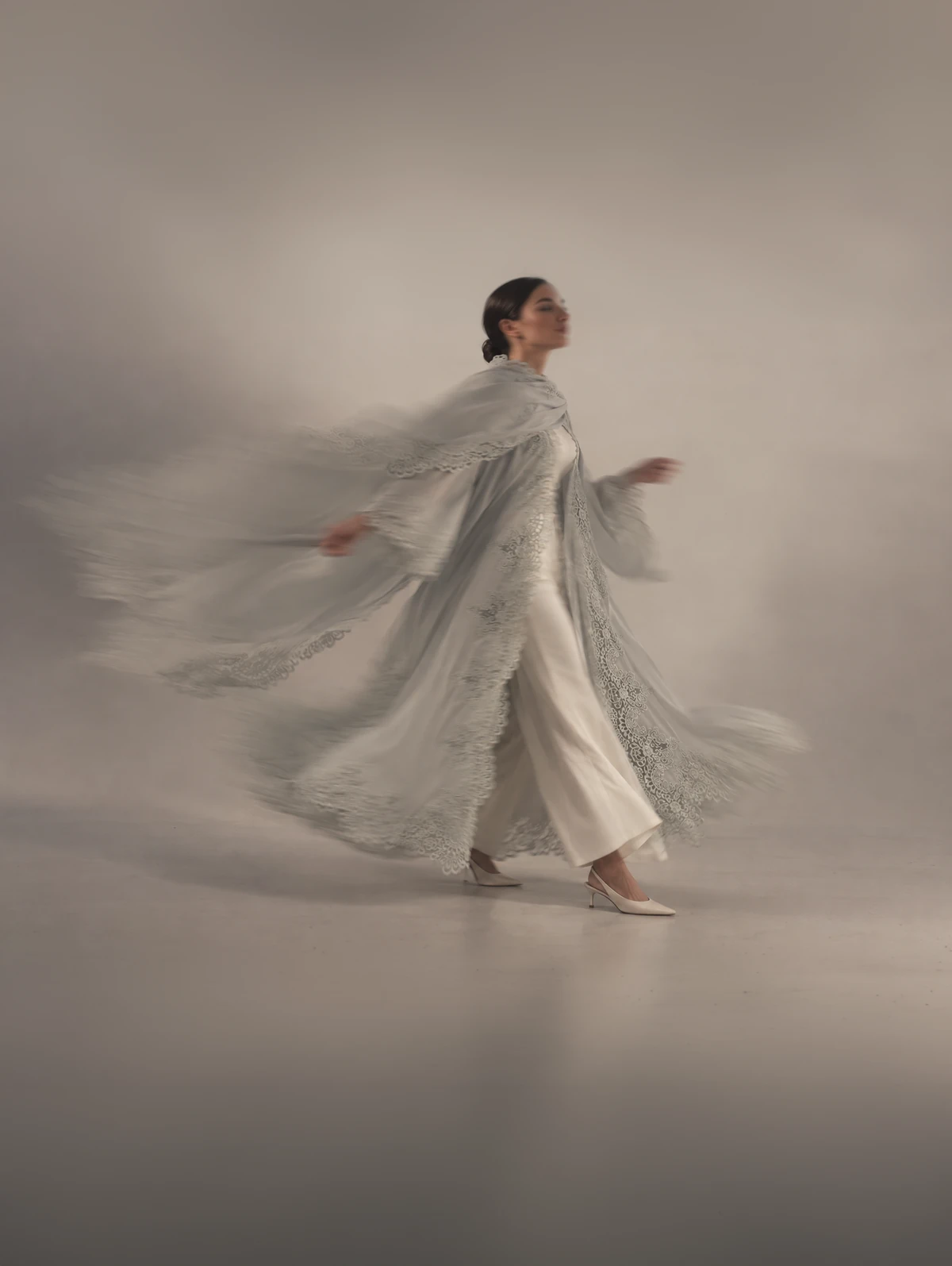 Sama in powder blue lace, the coat lifting as she turns.